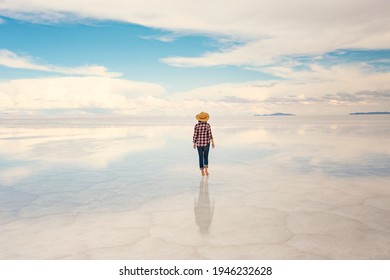 Girl back view wearing hat at Uyuni salt lake, Bolivia