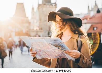 Girl With Backpack Looking At Map. Girl Visiting The Sights Praha In Holiday. Sun Flare.