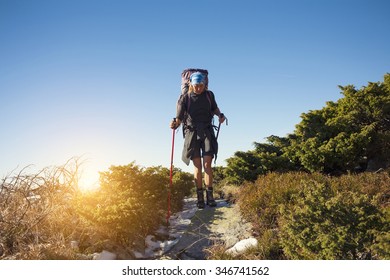 Girl with backpack is traveling in the mountains.