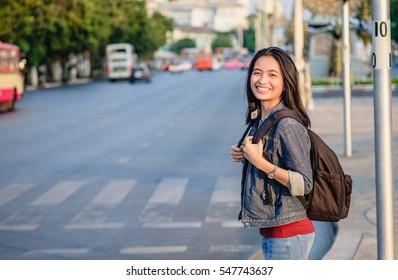 girl with bag smiling on street in Bangkok, across the road - Powered by Shutterstock