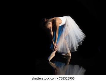 Girl ballerina posing and performing dance elements in blue scenic light on a black background - Shutterstock ID 738323905