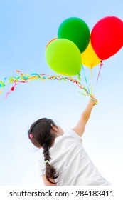 Girl with balloons flying in the sky