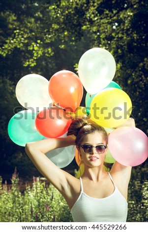 Girl with balloons in nature making facial expressions
