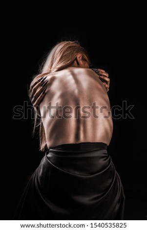 A girl with a bare back, severe thinness and protruding ribs. The concept of anorexia and bulimia, a disease of thin people. The struggle of the evil spirit in a girl, suffering and poverty