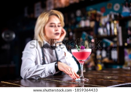 Girl barman makes a cocktail at the beerhall