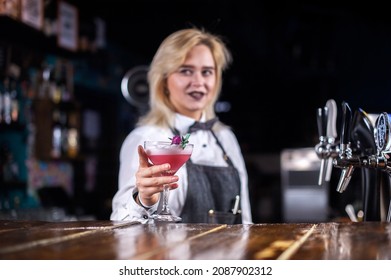 Girl barman mixes a cocktail on the public house