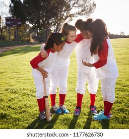 Girl baseball team in a team huddle, motivating before game