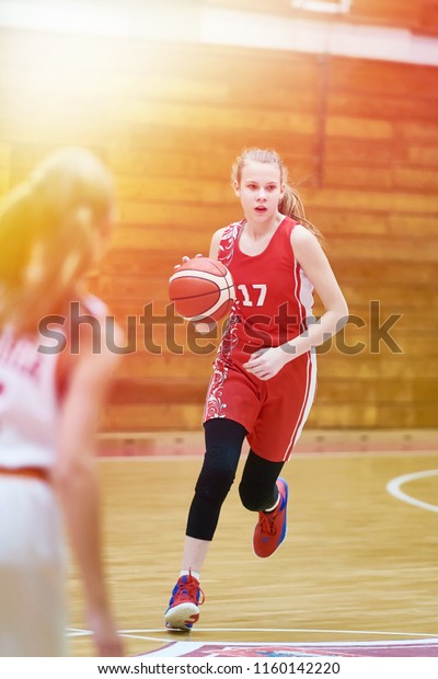 Girl basketball\
player with a ball in the\
game