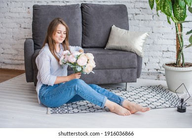 A girl with a beautiful bouquet is sitting on the floor