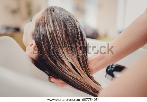 girl in a beauty\
salon. wash your hair, hair care, health. Process of washing your\
hair in a hairdresser