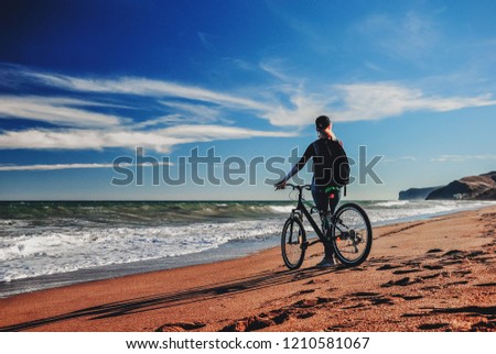 Girl with a bicycle walks alone on a deserted beach, concept of relaxation, silence, relaxation