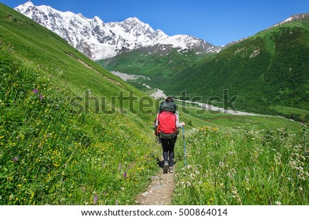 Girl with a big backpack is traveling in the Caucasus mountains, Georgia. Svaneti
