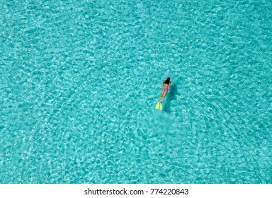 Girl in bikini snorkels through tropical, turquoise waters - Powered by Shutterstock