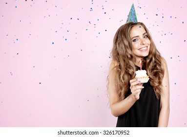 Girl with birthday cake on a pink background and confetti - Powered by Shutterstock