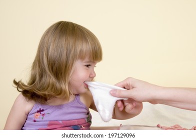 A Girl Biting On An Object While Someone Is Holding The Other Side.