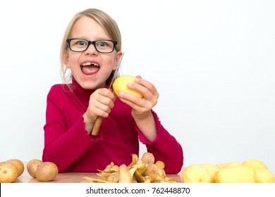 Girl with black glasses is peeling potatoes