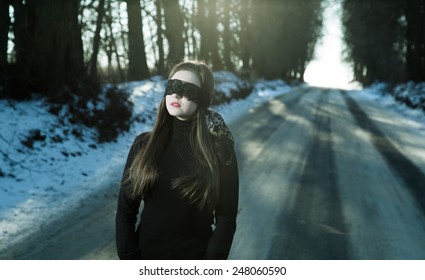 Girl with a blindfold on the background of gloomy road - Shutterstock ID 248060590