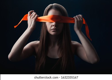 the girl blindfolded herself, with red tape, for a game on a black background
