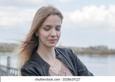Girl with blond hair on the promenade near river