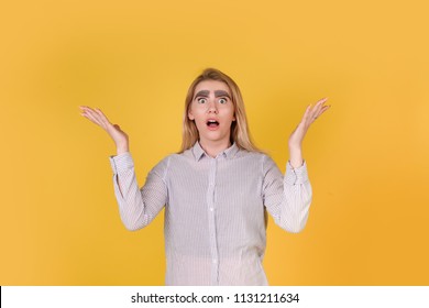 The girl with blonde hair and thick drawn eyebrows is surprised on yellow background. a joke with eyebrows. it's funny about the eyebrows