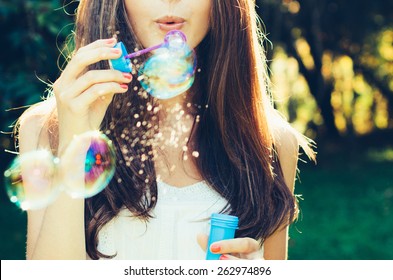 Girl blowing bubbles outdoor. Focus on lips. - Powered by Shutterstock