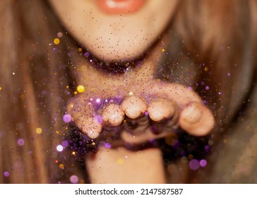 A Girl Blowing Millions Of Pieces Of Colorful Glitter From Her Hand