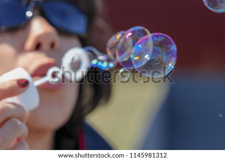 Girl blowing soap bubbles in the nature