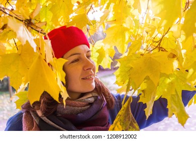 Girl in blue coat and red beret during Golden autumn in Park - Shutterstock ID 1208912002