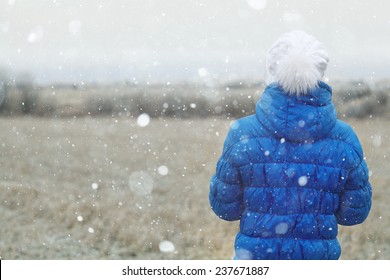 girl in a blue down jacket winter view from the back