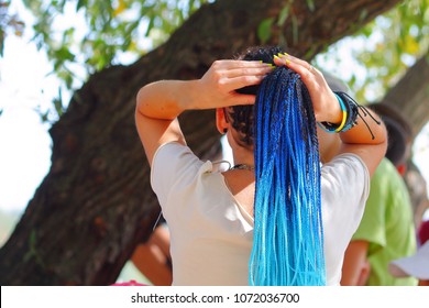 Girl With Blue Dreadlocks Straightens Her Hair. Back View