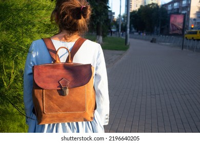 Girl In Blue Dress Wears Leather Fashion Handmade Bag On The Street. Leather Backpack Craft Product. Kiev, Ukraine.