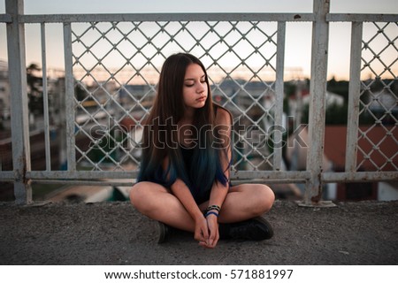 girl with blue hair sitting during sunset