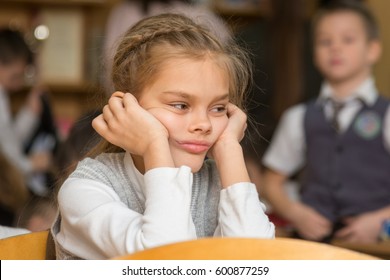 Girl bored at school sitting at a desk on the reverse