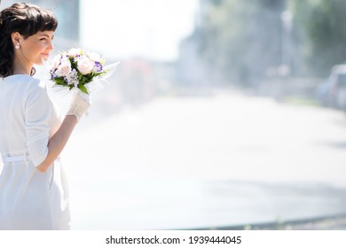 Mädchen mit Bouquet steht auf dem Hintergrund der Fontäne