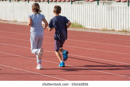 Girl And Boy Jogging On Tartan Track