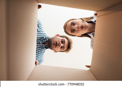 The Girl And The Boy Are Looking At The Empty Box. View From Inside The Box Close-up.