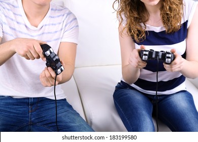 Girl And Boy Playing Video Games At Home