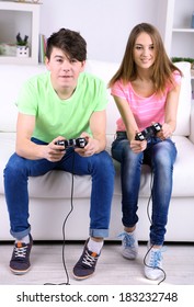 Girl And Boy Playing Video Games At Home