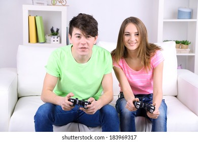 Girl And Boy Playing Video Games At Home