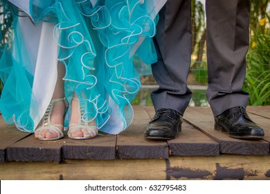 Girl And Boy Prom Couple In Formal Suit And Dress With Focus On Their Feet In Fancy Shoes On Wooden Bridge