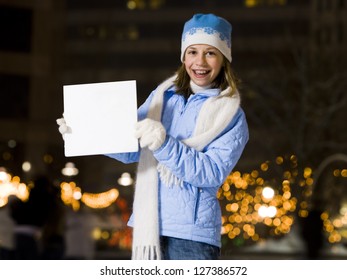 Girl With Braces Smiling Outdoors In Winter Holding A Blank Board