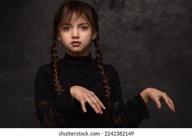 A girl with braids in a gothic style on a dark background