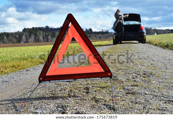 Girl, broken car and\
triangle