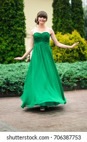 girl brunetka . Dressed in a beautiful green dress , ball . beautiful hair and make-up Golden purse - Shutterstock ID 706387753
