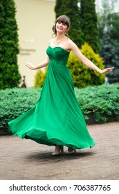 girl brunetka . Dressed in a beautiful green dress , ball . beautiful hair and make-up Golden purse - Shutterstock ID 706387765