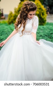 girl brunetka . Dressed in an elegant wedding dress , ball . beautiful hair and makeup - Shutterstock ID 706003531