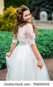 girl brunetka . Dressed in an elegant wedding dress , ball . beautiful hair and makeup - Shutterstock ID 706003543
