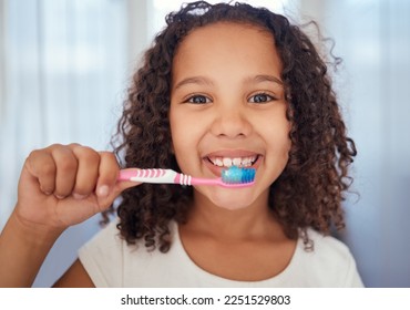 Girl, brush and smile with teeth for dental, care and clean hygiene in fresh oral healthcare at home. Portrait of a happy female child, face and toothbrush smiling in bathroom for morning routine - Shutterstock ID 2251529803