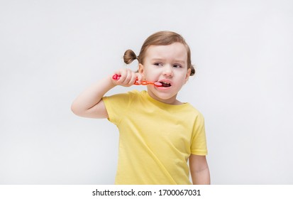 The Girl Brushes Her Teeth With A Toothbrush. Tooth Decay. It's A Problem With Teeth. Toothache.On White Background With Copy Space.