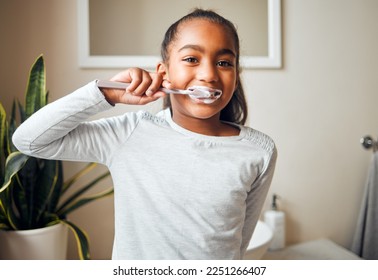 Girl brushing teeth, portrait and toothbrush for hygiene with clean mouth and fresh breath with dental health. Kid, cleaning with toothpaste in bathroom and wellness at family home with healthy gums - Powered by Shutterstock